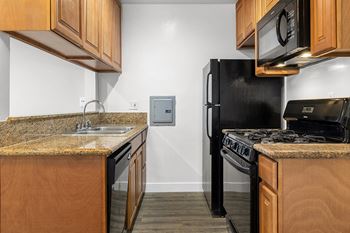 A kitchen with black appliances and granite counter tops
